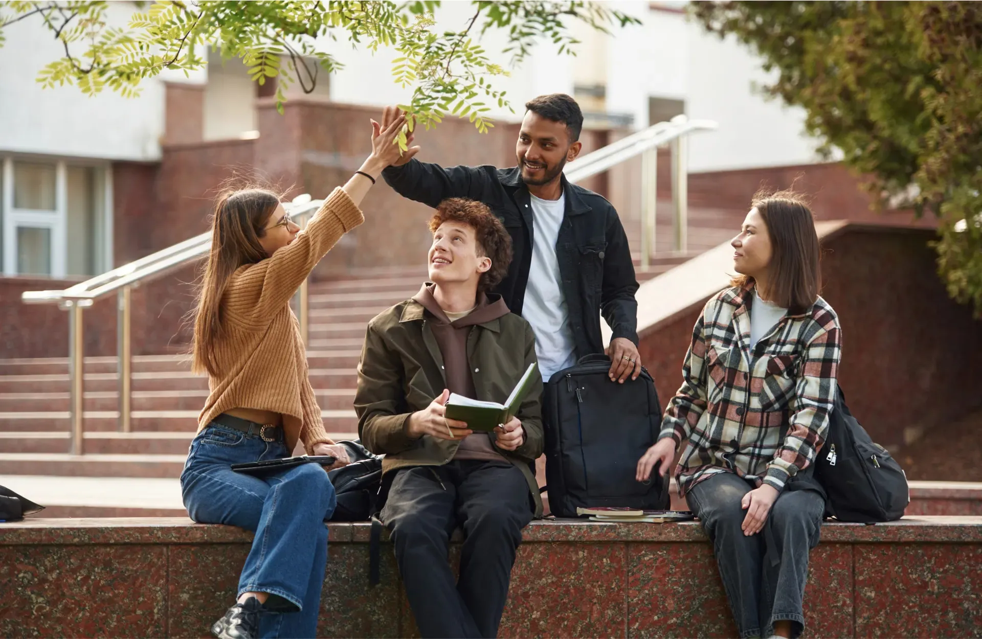 Friends sharing a high five on campus steps